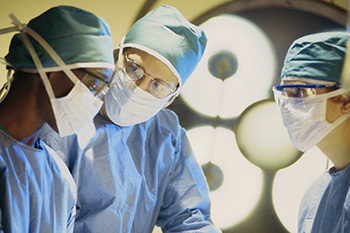 Doctors in the operating room under bright lights. 